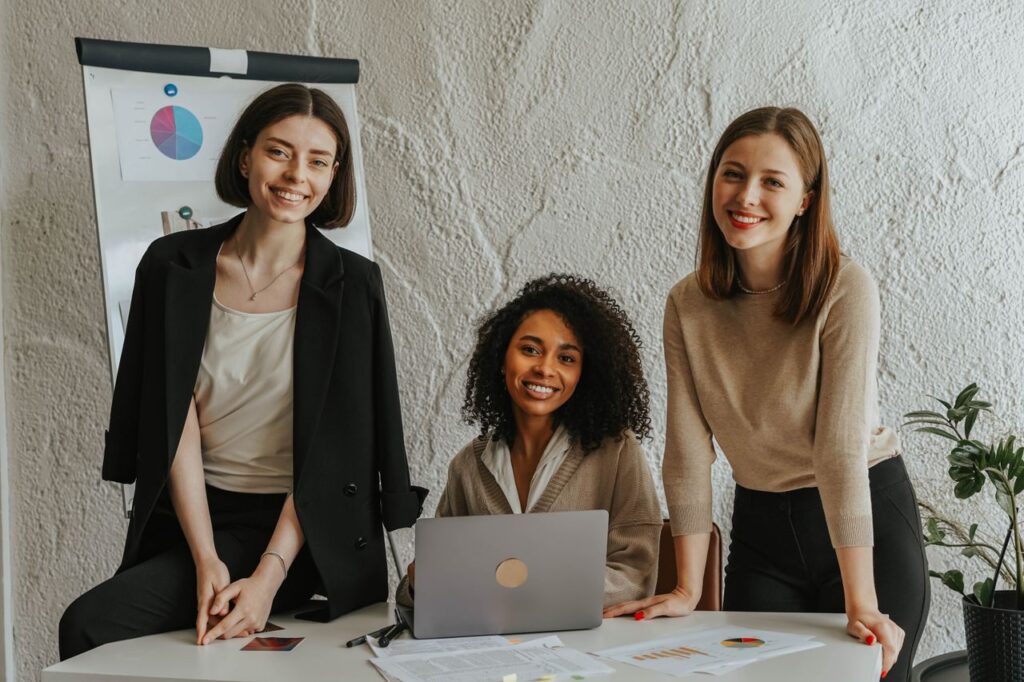 pexels-photo-8145262-8145262 Diverse group of women engaged in a business meeting, smiling and collaborating.