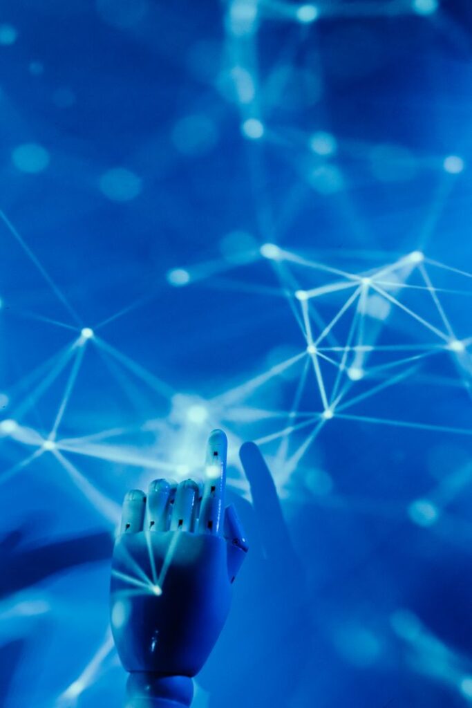 pexels-photo-8386437-8386437 Futuristic robotic hand touching a digital network on a blue background.